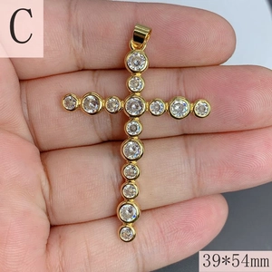 Detailed view of large gold cross pendant with clear zircons measuring 39mm by 54mm