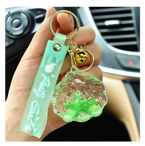 Detail of mint green acrylic shell keychain with flowing sand and Pretty Good strap