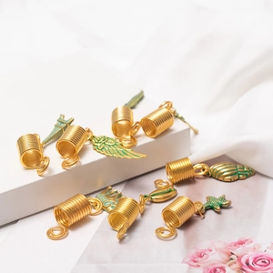 Golden dreadlock hair rings with wing shell and starfish charms on a white background