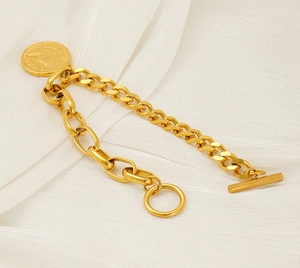 Detailed view of vintage gold coin pendant bracelet with OT toggle clasp on white silk