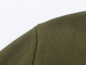 Macro view of army green knitted cardigan showing precise shoulder seam stitching details