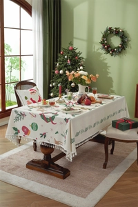 Close-up of Christmas tablecloth featuring Santa motifs, festive patterns and tassel edges