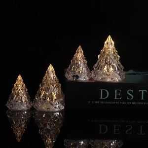 Close-up of crystal Christmas tree lights emitting warm yellow glow on reflective surface