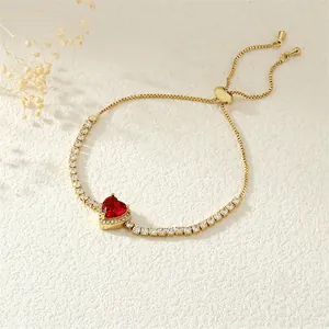 Detail view of heart-shaped red zircon and white stones on golden adjustable bracelet