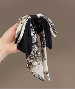 Détail de la pince à cheveux noeud en soie avec motif floral à l'encre noire et blanche et tissu