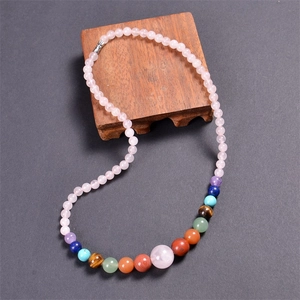 Detail of 6mm pink crystal and colorful natural stone beads on a rustic wooden display