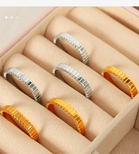 Detail of 18k gold and silver gear textured rings displayed in a velvet jewelry box