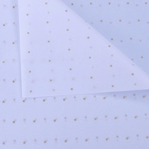 Close-up of light purple tissue paper with gold star patterns and translucent texture