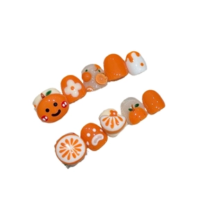 Handmade orange cartoon press-on nails for kids featuring cute fruit art and floral patterns