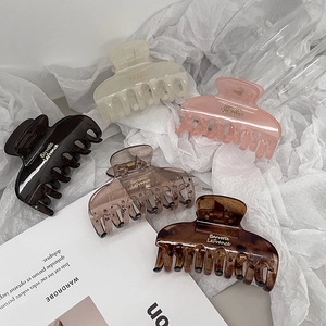 Flat lay of five elegant matte hair claws in assorted colors on soft fabric