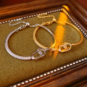 Detailed close-up of 18k gold plated bracelets with sliding diamond in green velvet box