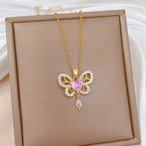Luxurious gold butterfly necklace with pink heart gemstone and sparkling tassel detail