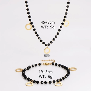 Elegant jewelry set with black glass faceted beads and a gold round pendant necklace