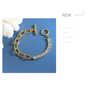 Detail of gold chain bracelet with rectangle zircons and OT clasp on blue backdrop