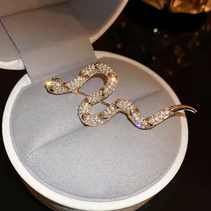 Gold plated snake brooch with cubic zirconia crystals in a jewelry box
