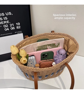 Detail showing the large storage capacity of the straw tote bag with various personal items