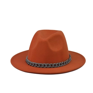Detail shot of orange felt fedora featuring grey chain decoration and a wide flat brim
