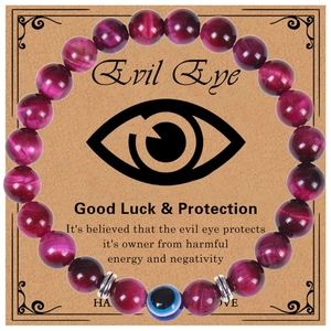 Close-up of pink tiger eye beads bracelet with blue evil eye charm on a vintage card