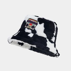 Detail of plush cow print bucket hat with vintage cassette tape embroidery patch