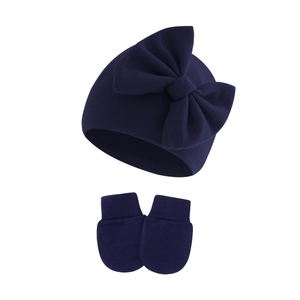 Detailed knit texture of dark blue baby hat and mitten set with large bow detail
