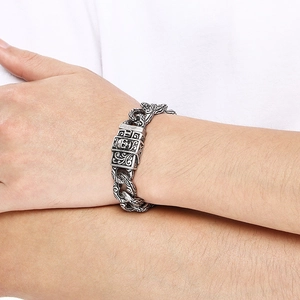Close-up of vintage steel Cuban chain bracelet with gothic skull clasp on wrist