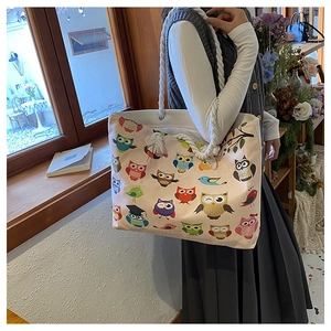 Detail of canvas tote bag showing thick cotton rope handles and colorful owl pattern