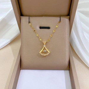 Detailed view of a gold fan-shaped necklace pendant with zircon stones in a gift box