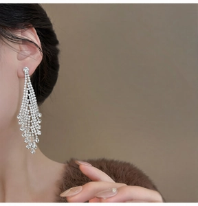 Detailed view of silver diamond tassel earrings on a model showing the long fringe effect