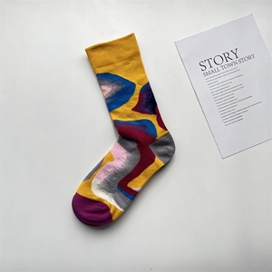 Detail of yellow cotton sock with artistic abstract jacquard pattern in blue and red