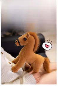 Détail d'un poney en peluche marron doux montrant une crinière et un licol noir