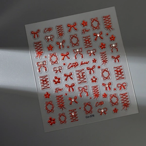 Detail of red embossed bow nail stickers with gold accents and sparkling crystals