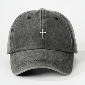 Close-up of white cross embroidery on washed black cotton vintage baseball cap