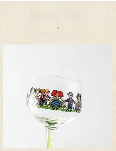 Detail of colorful folk art doll pattern and green glass stem on Alsace wine goblet