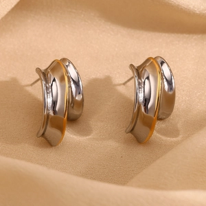 Macro shot of 18K gold-plated knight helmet stud earrings on a champagne silk background