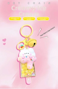 Detail of bunny cream popsicle keychain with liquid glitter, yellow beads and a bell charm