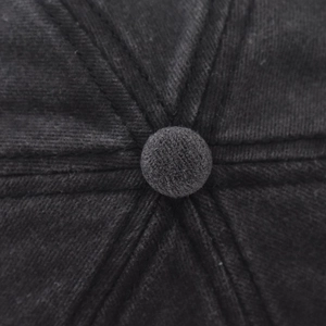 Detail shot of the six-panel crown structure and top button on a black washed cotton cap