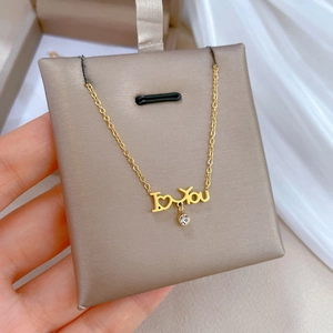 Macro view of gold Love you letter pendant with sparkling crystal on necklace detail