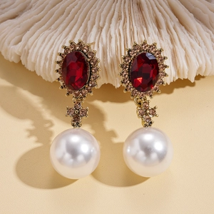 Detail of luxury vintage drop earrings with red crystal and large white pearl pendant