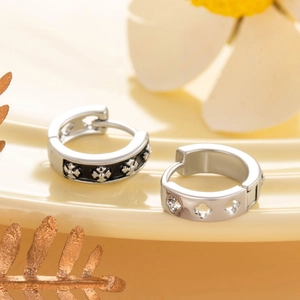 Boucles d'oreilles créoles argentées avec motif croix noire pour un look de bijou épuré