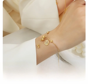 Detail of 18K gold plated steel bracelet with Fu character and lucky gourd charm