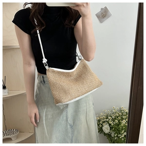 Mirror selfie showing a woven tote bag with white leather straps and knot detail on a model