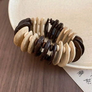 Detailed view of coconut shell and wooden beads on an elastic ethnic style bracelet