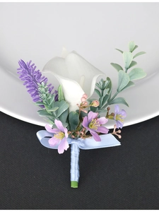 Detailed view of white calla lily boutonniere with purple accents and light blue ribbon