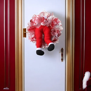 Christmas wreath with Santa legs and red mesh ribbon on a white door entrance