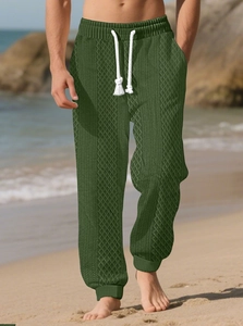 Détail du jogging en tricot vert foncé avec cordons blancs et tissu jacquard texturé