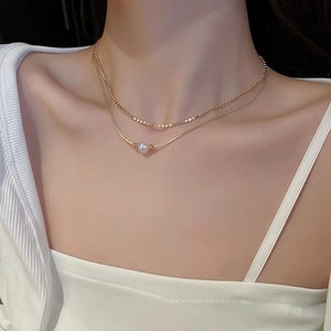 Double-layered golden necklace with sleek snake chain and pearl pendant for women