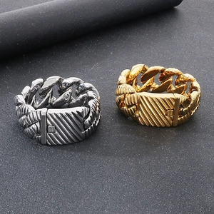 Close-up of punk style thick Cuban chain bracelets in gold and silver finish steel