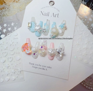 Detailed view of handmade 3D shell and starfish nail art tips with pearls and rhinestones
