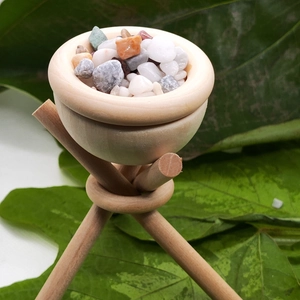 DIY essential oil diffuser with wooden tripod and colorful aroma stones on green leaves