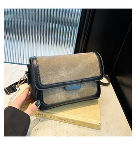 Detailed close-up of brown vintage square bag with black edges and gold metal buckle